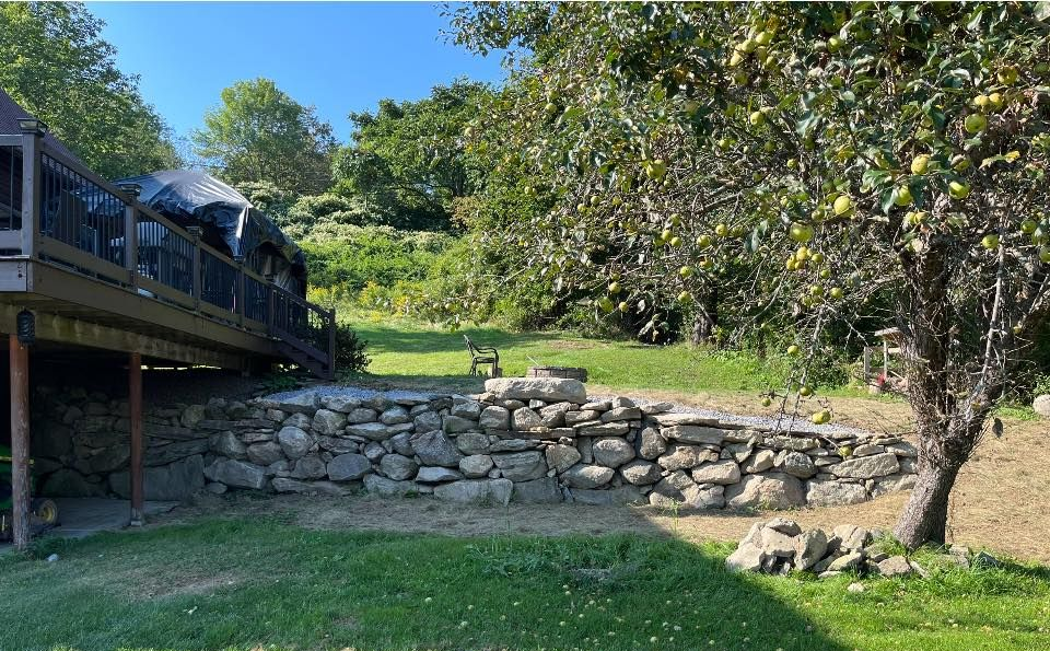 A white bathtub with beige tile walls and floor. A soap dish is mounted on the wall.