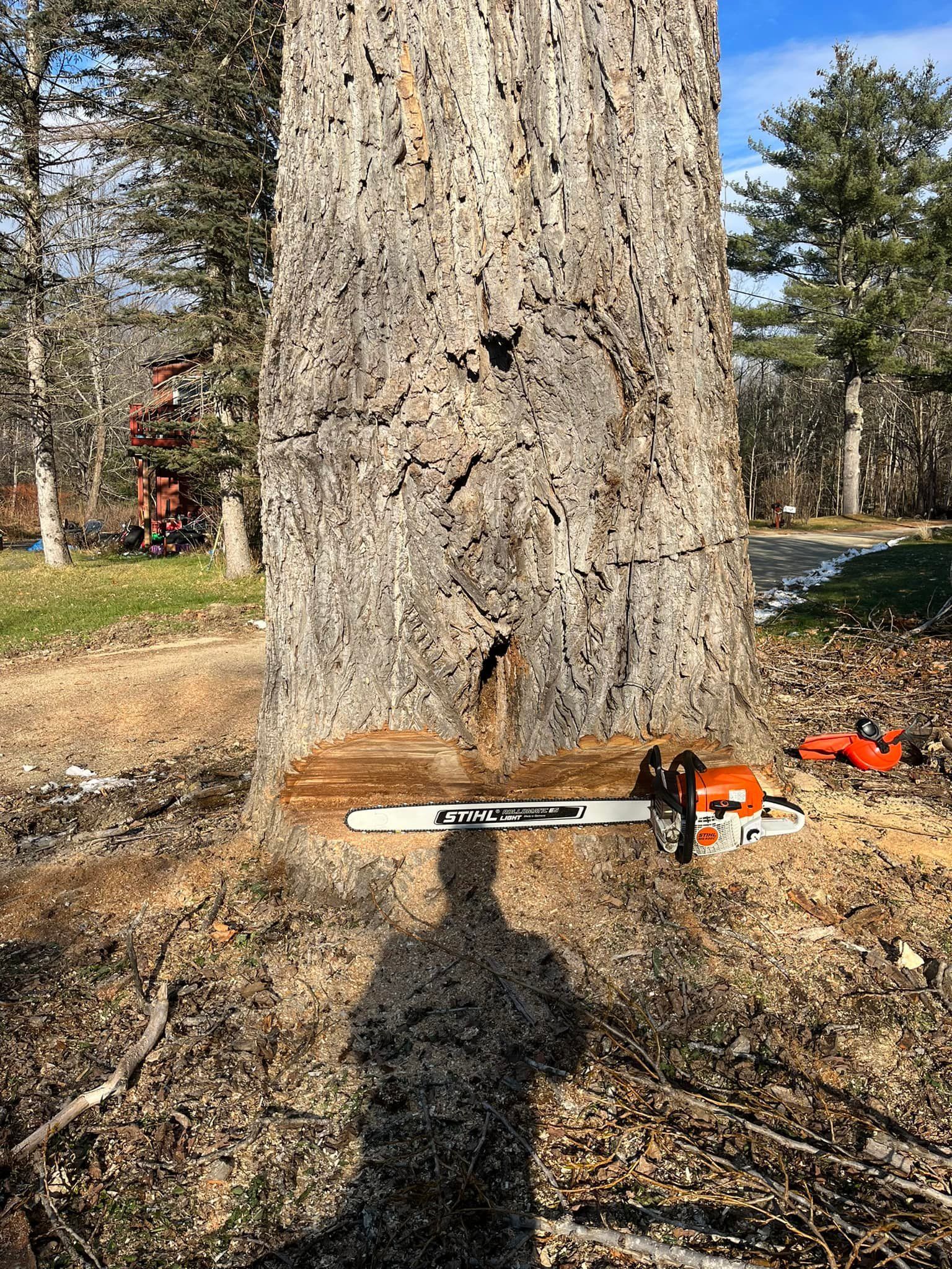 White bathtub with tiled walls in a bathroom, light brown floor, faucet on the side.