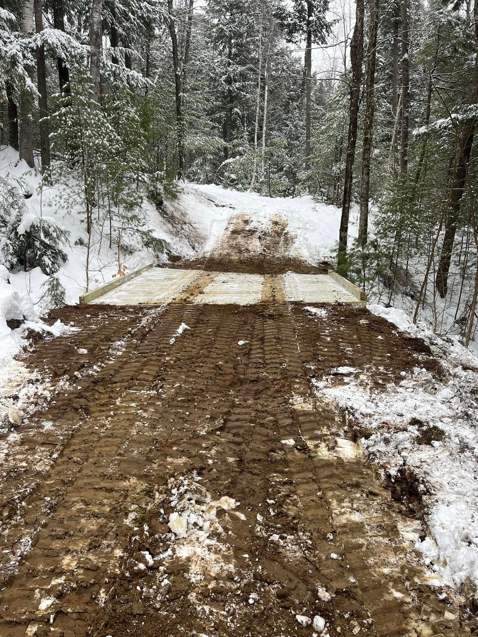 Two men are standing in an empty room with black walls