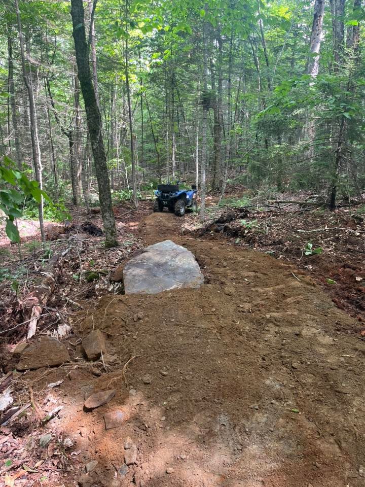 A construction worker wearing a blue hard hat is working on a roof