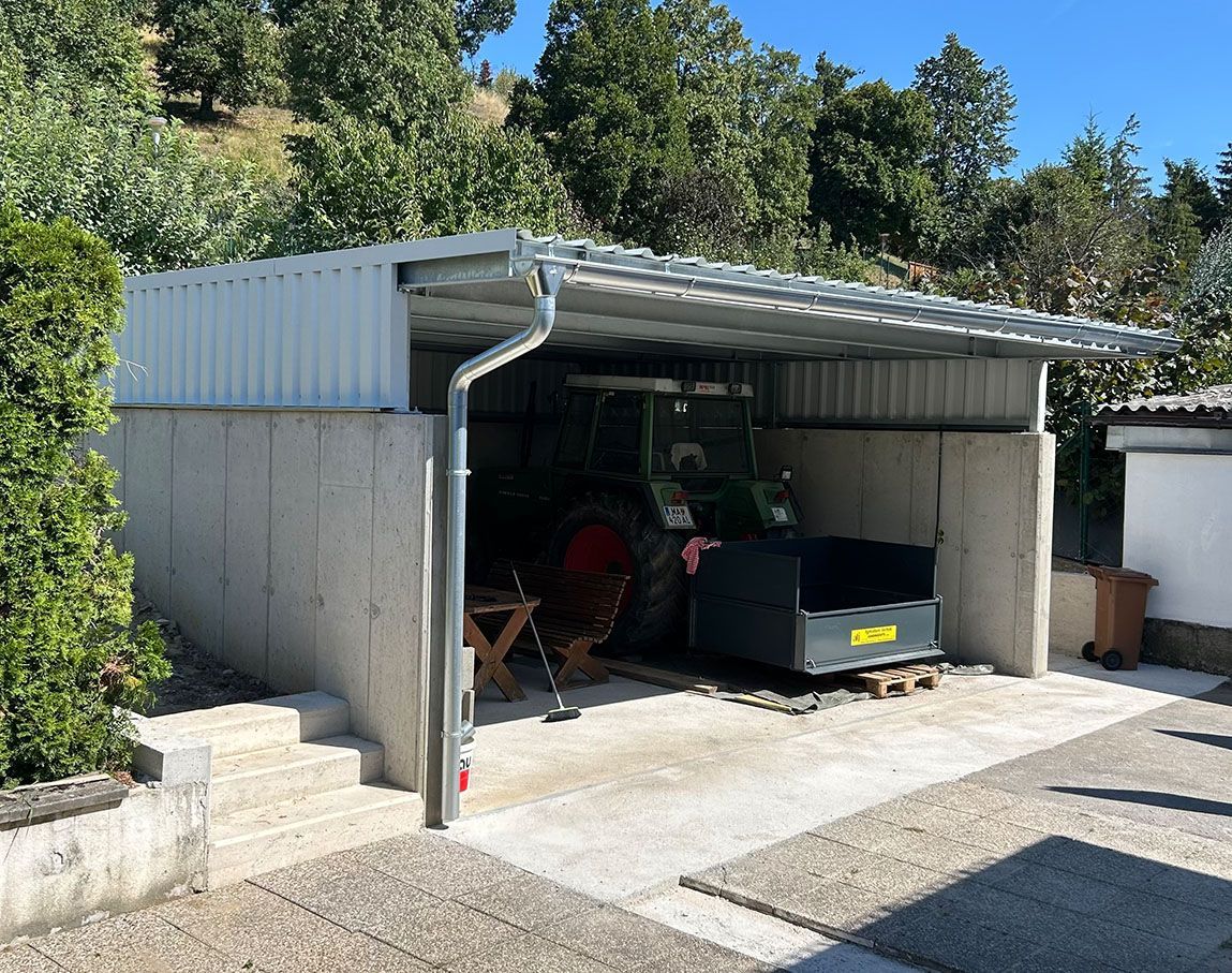 Ein weißes Haus mit einer Terrasse, einer Terassenüberdachung und einem Tisch davor