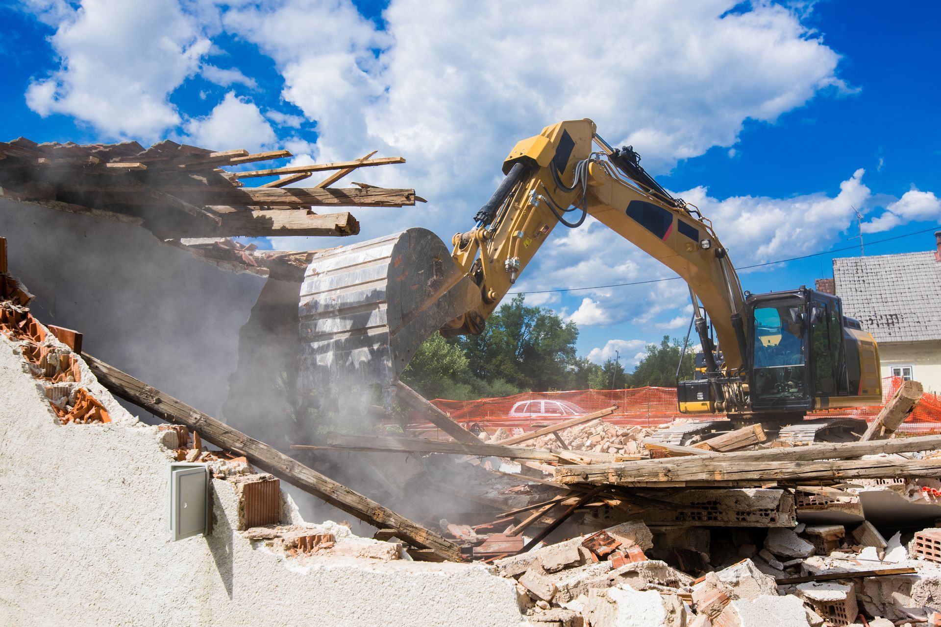The demolition of an old house showcases debris and building demolition contractors at work.