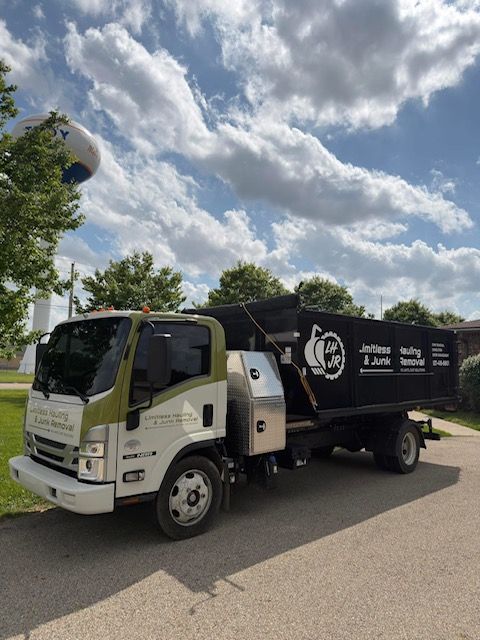 White and black waste truck parked on a road under a cloudy sky White and black waste truck parked on a road under a cloudy sky