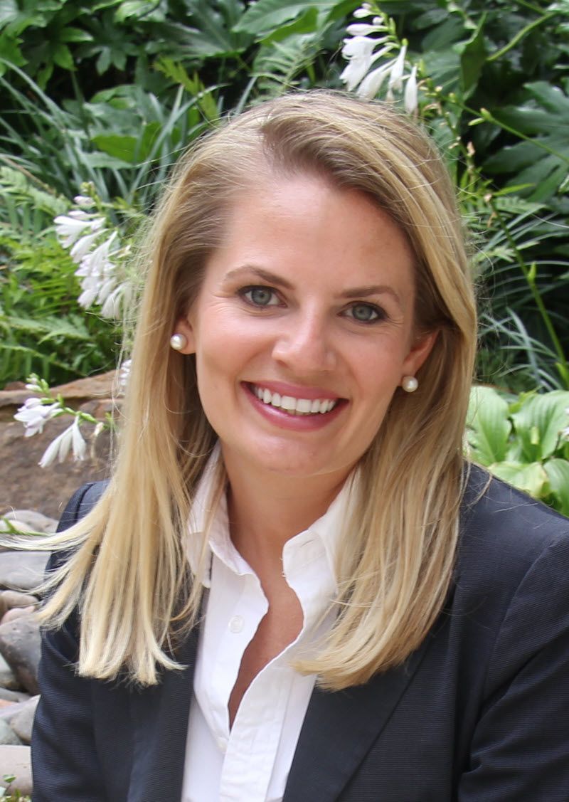 A man in a grey shirt is smiling for the camera