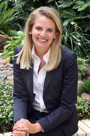 A man in a grey shirt is smiling for the camera