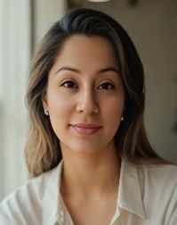 Woman with long brown hair, wearing a white shirt, smiling.