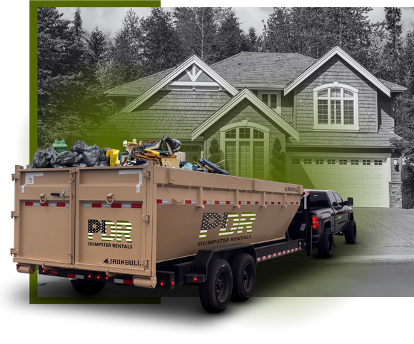 A PDR dumpster truck in front of a house