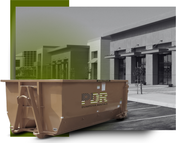 A PDR dumpster truck in front of a a commercial building