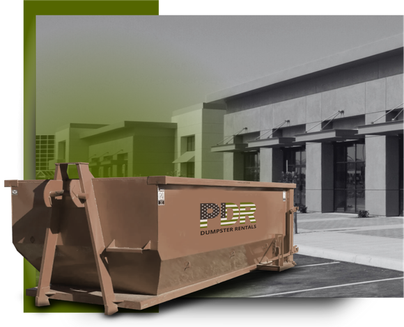 A PDR dumpster truck in front of a a commercial building