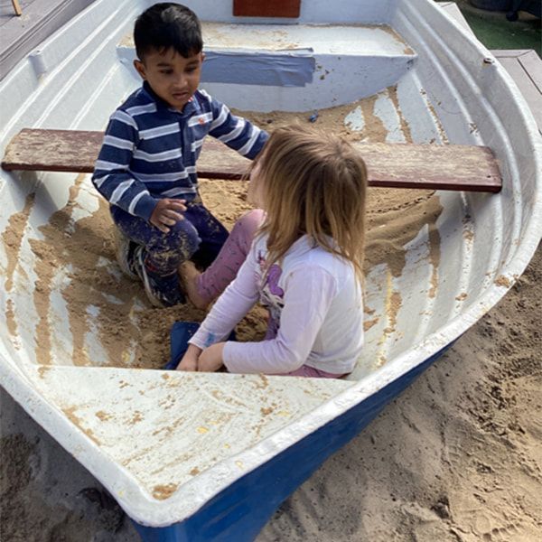 A Boy and a Girl Are Sitting in a Boat in the Sand — Mt Ousley Pre School in Fairy Meadow, NSW