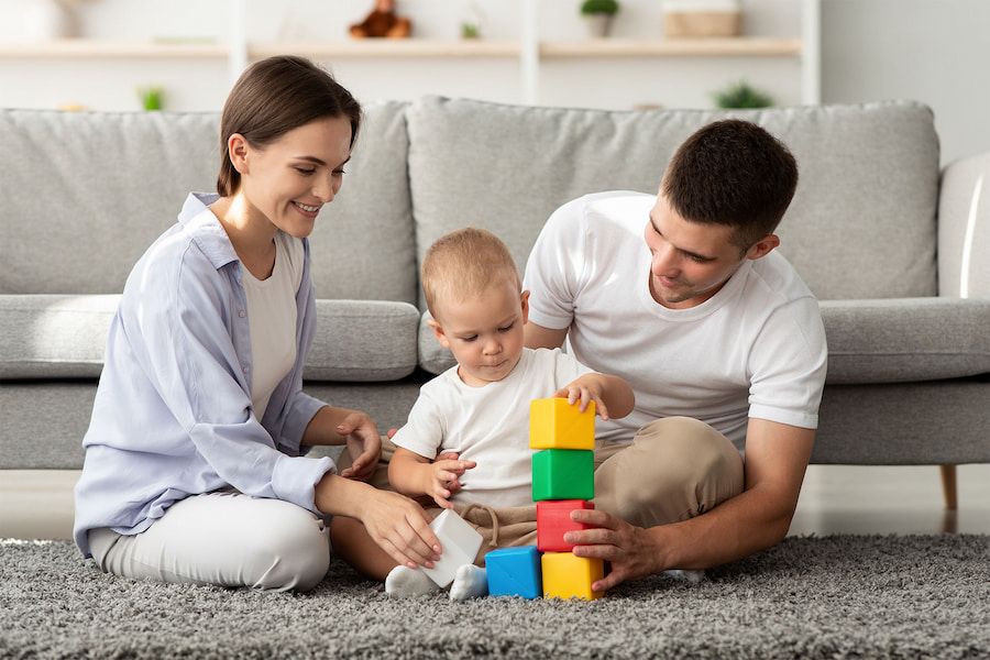 A Family is Playing With Blocks on the Floor in a Living Room — Mt Ousley Pre School in Fairy Meadow, NSW  