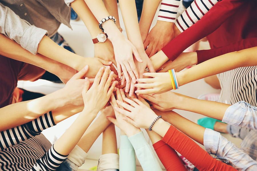 A Group of People Are Putting Their Hands Together in a Circle — Mt Ousley Pre School in Fairy Meadow, NSW