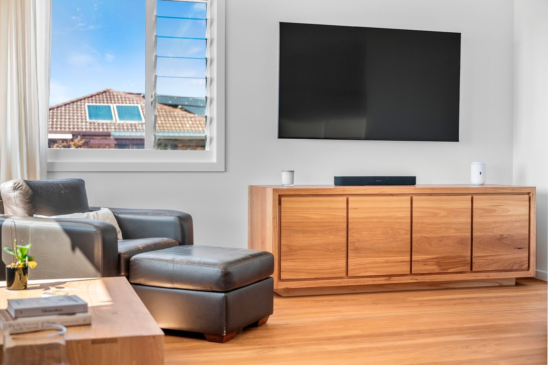 A Living Room With a Large Flat Screen Tv and Cabinet — Plumbe Joinery in Coffs Harbour, NSW