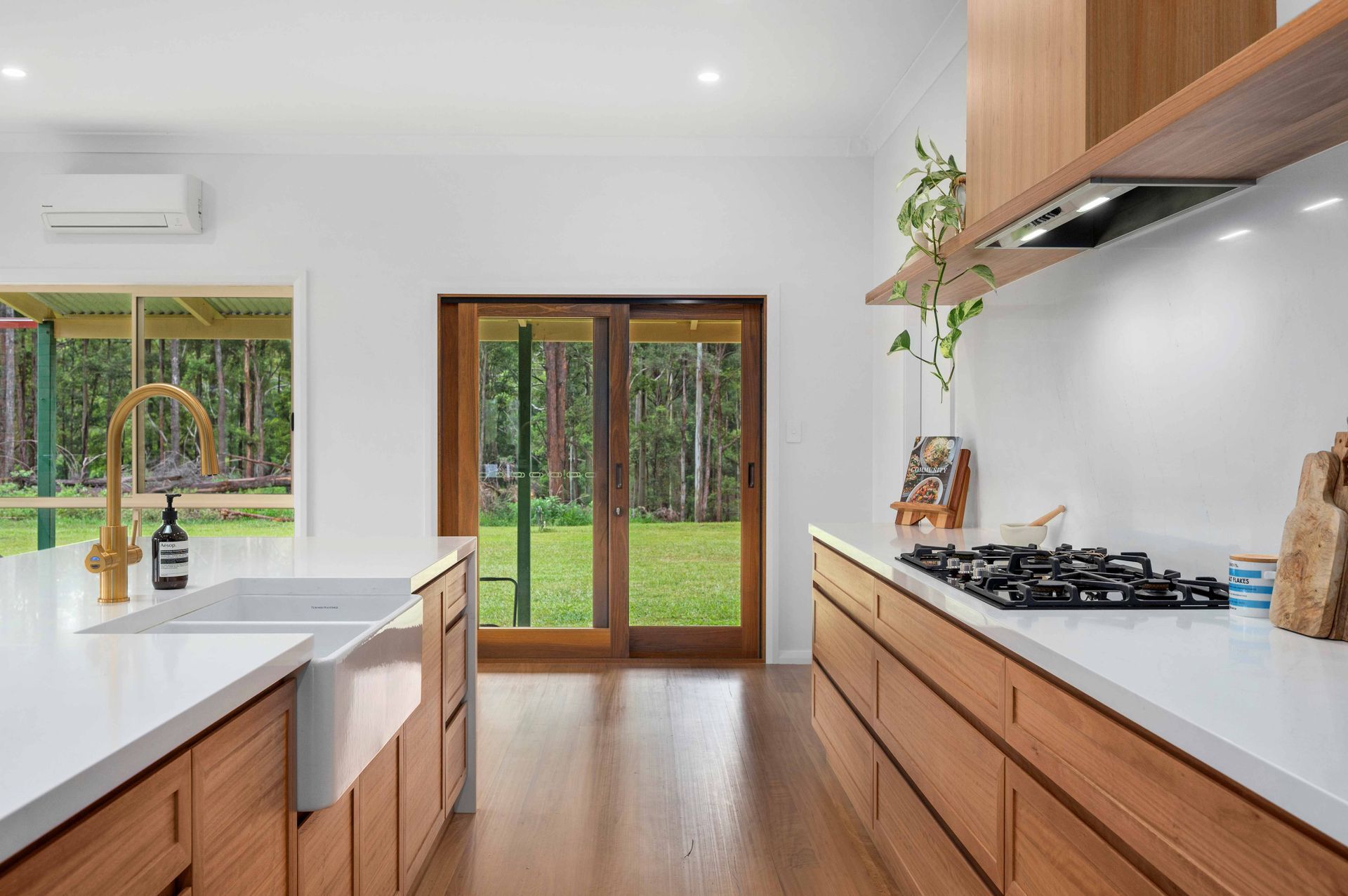 A Kitchen With Wooden Cabinets and a Stove Top Oven — Plumbe Joinery in Coffs Harbour, NSW