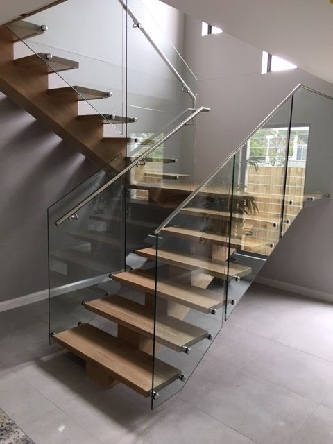 A Staircase With a Glass Railing and Wooden Step — Plumbe Joinery in Coffs Harbour, NSW