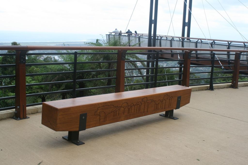 A Wooden Bench on a Deck With a Bridge in the Background — Plumbe Joinery in Coffs Harbour, NSW