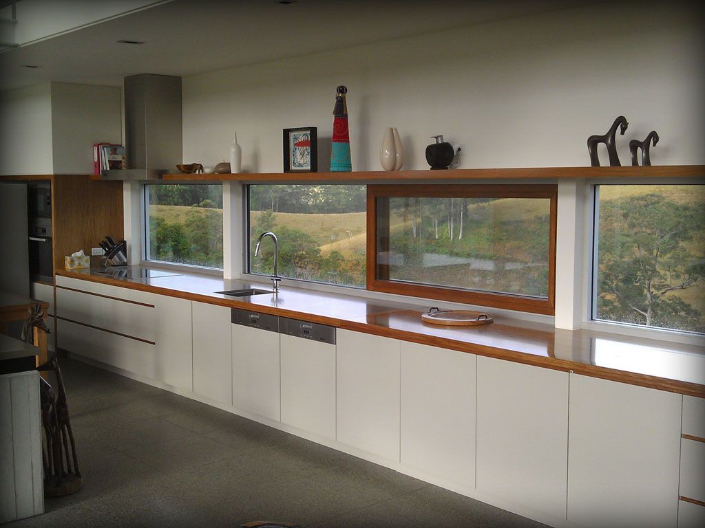 A Kitchen With White Cabinets and a Large Window — Plumbe Joinery in Coffs Harbour, NSW