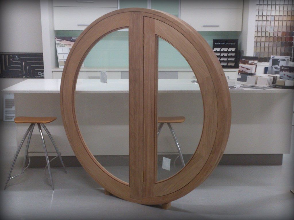 A Large Round Wooden Window Inside A Kitchen — Plumbe Joinery in Coffs Harbour, NSW