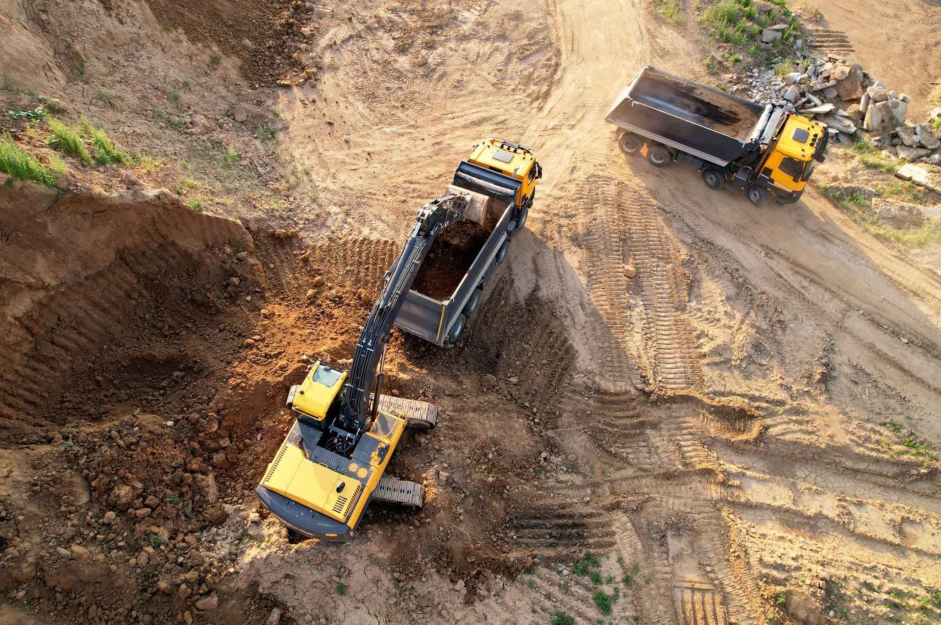 Excavator loading a dump truck with dirt at a construction site
