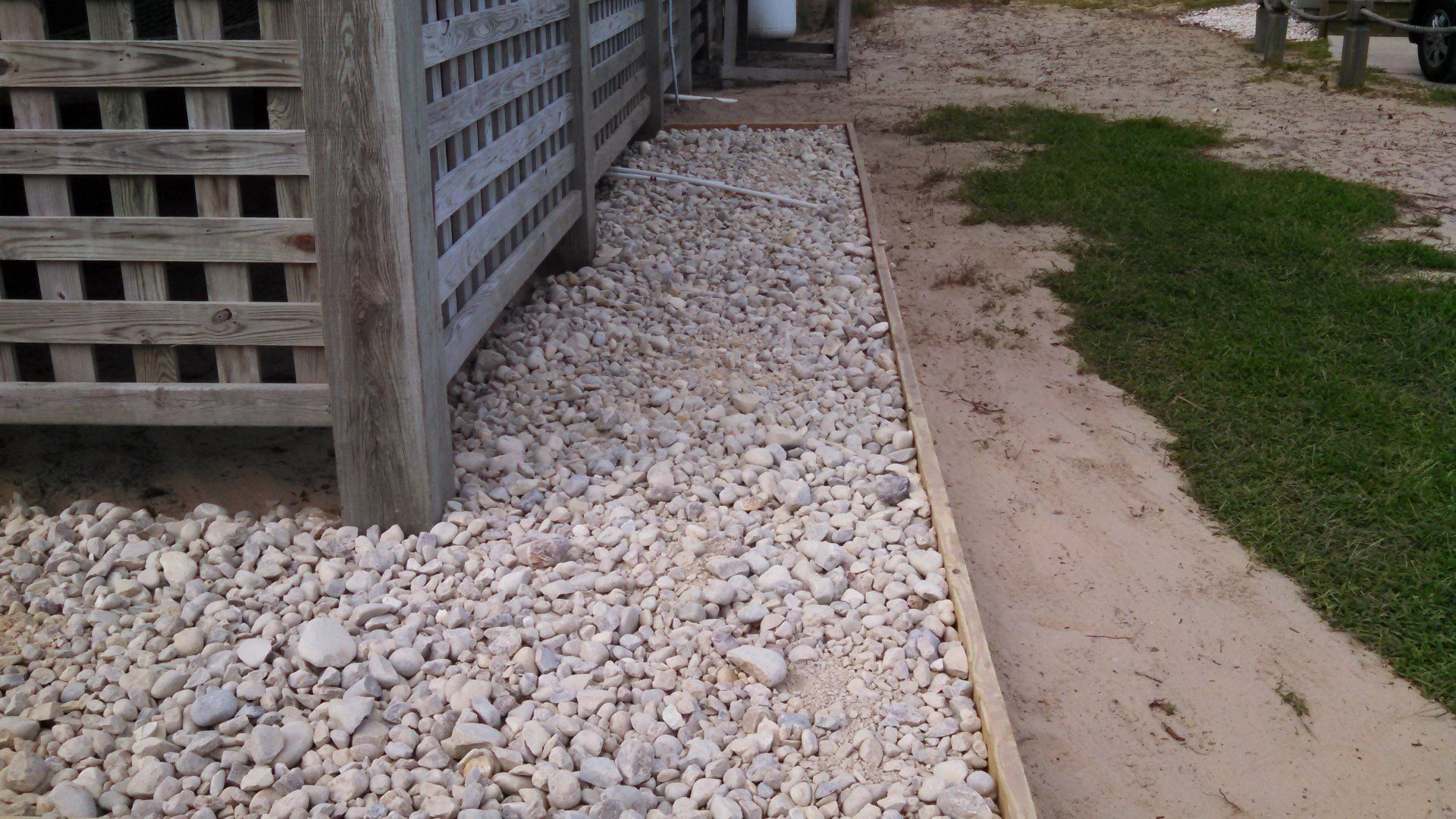 Number 3 rock bordering a lattice fence.