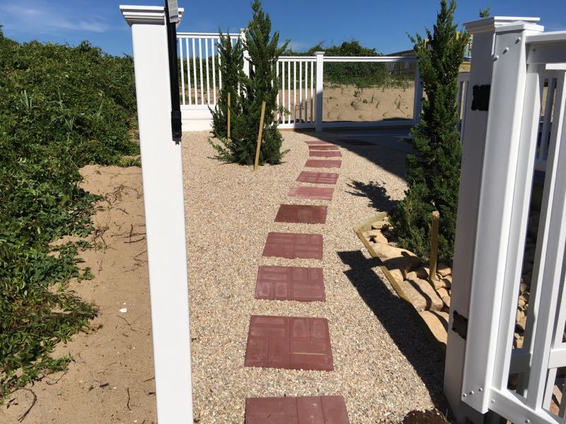 Red square paver embedded in pea rock