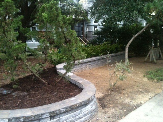 Stone retaining wall bordering driveway