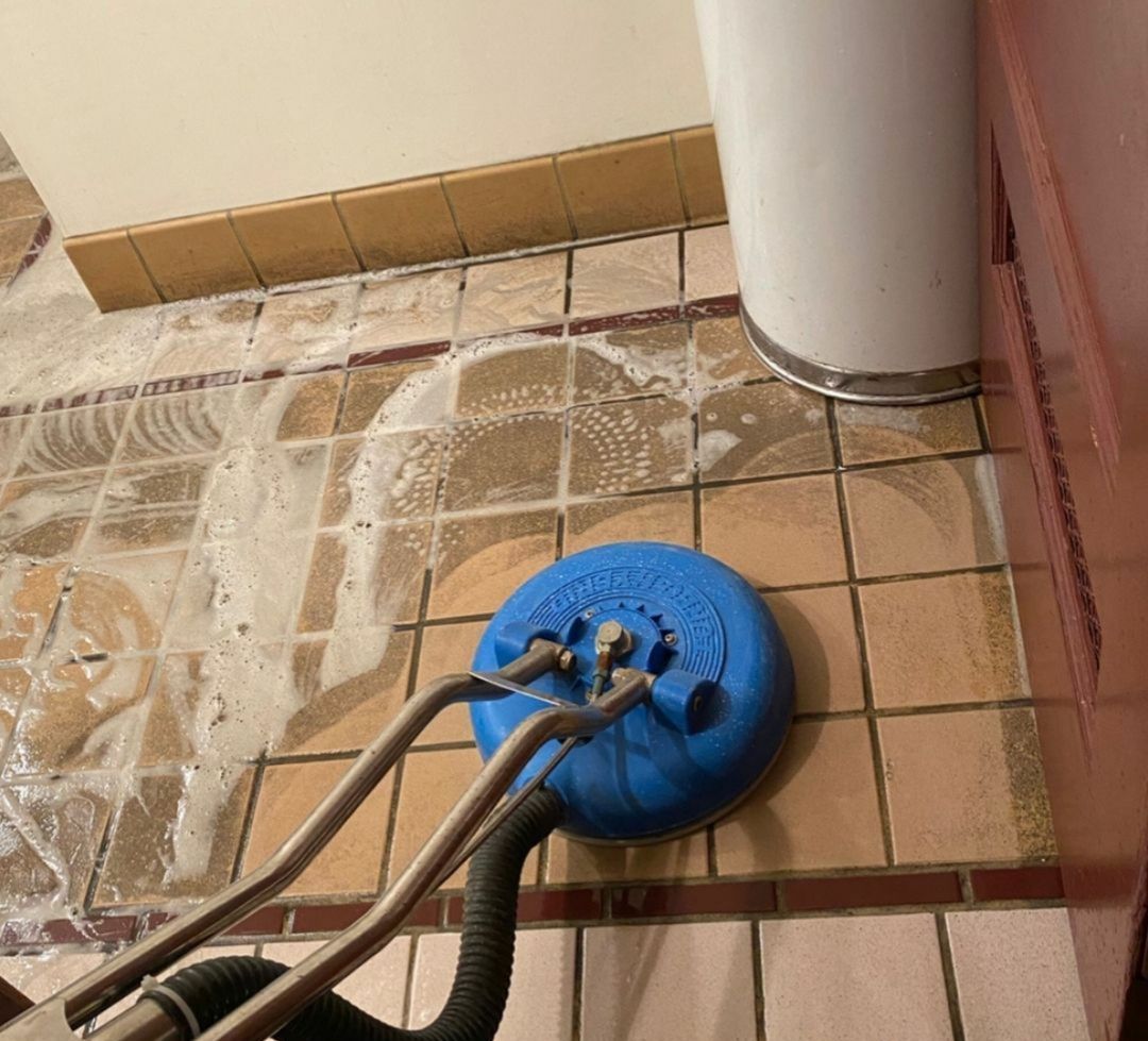 A blue vacuum cleaner is sitting on a tiled floor