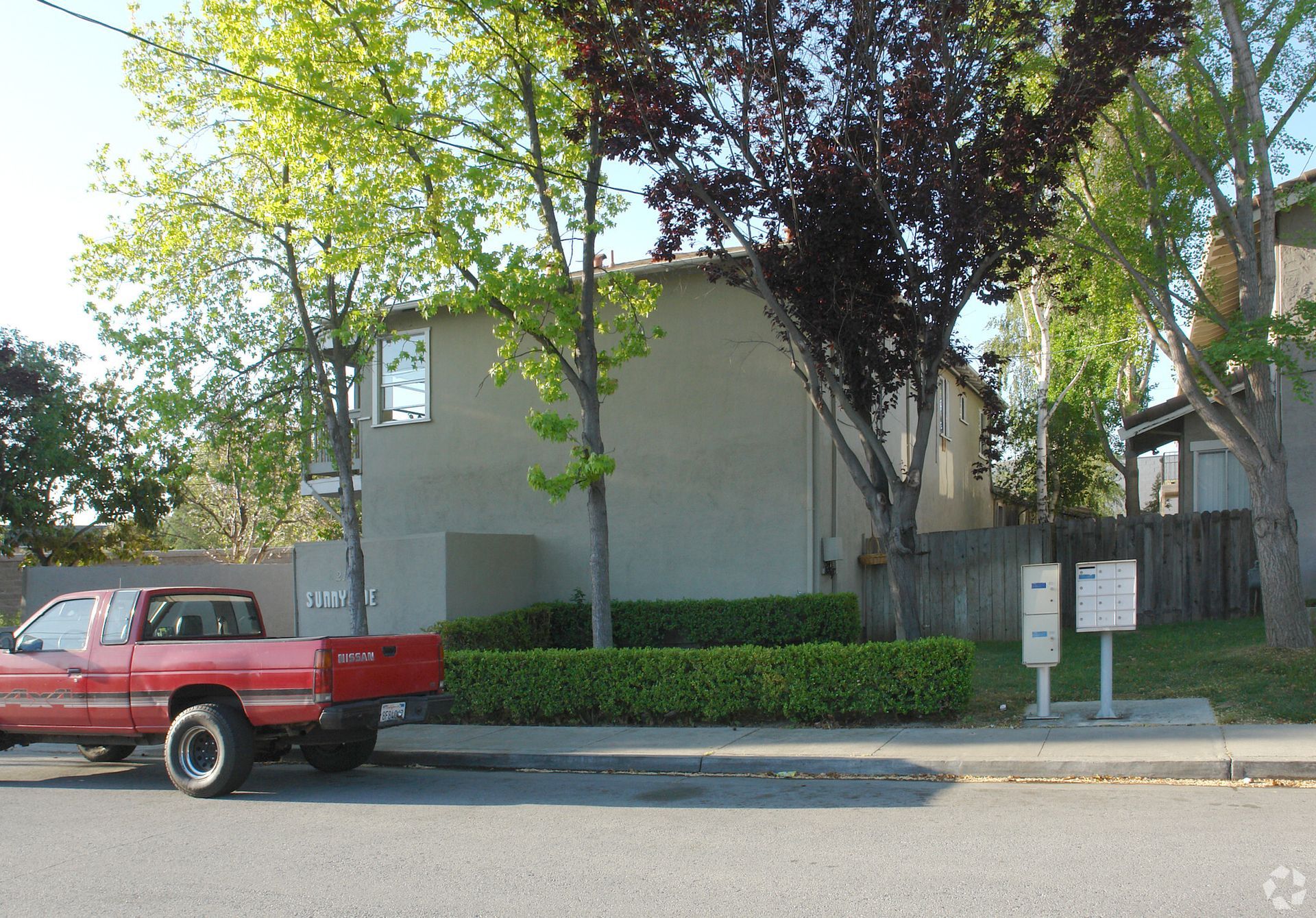 A red truck is parked in front of a house