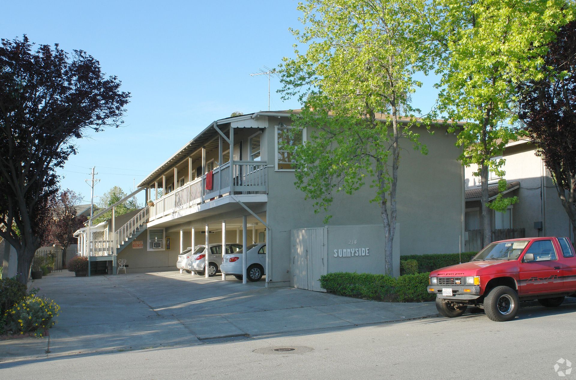 A red truck is parked in front of a building