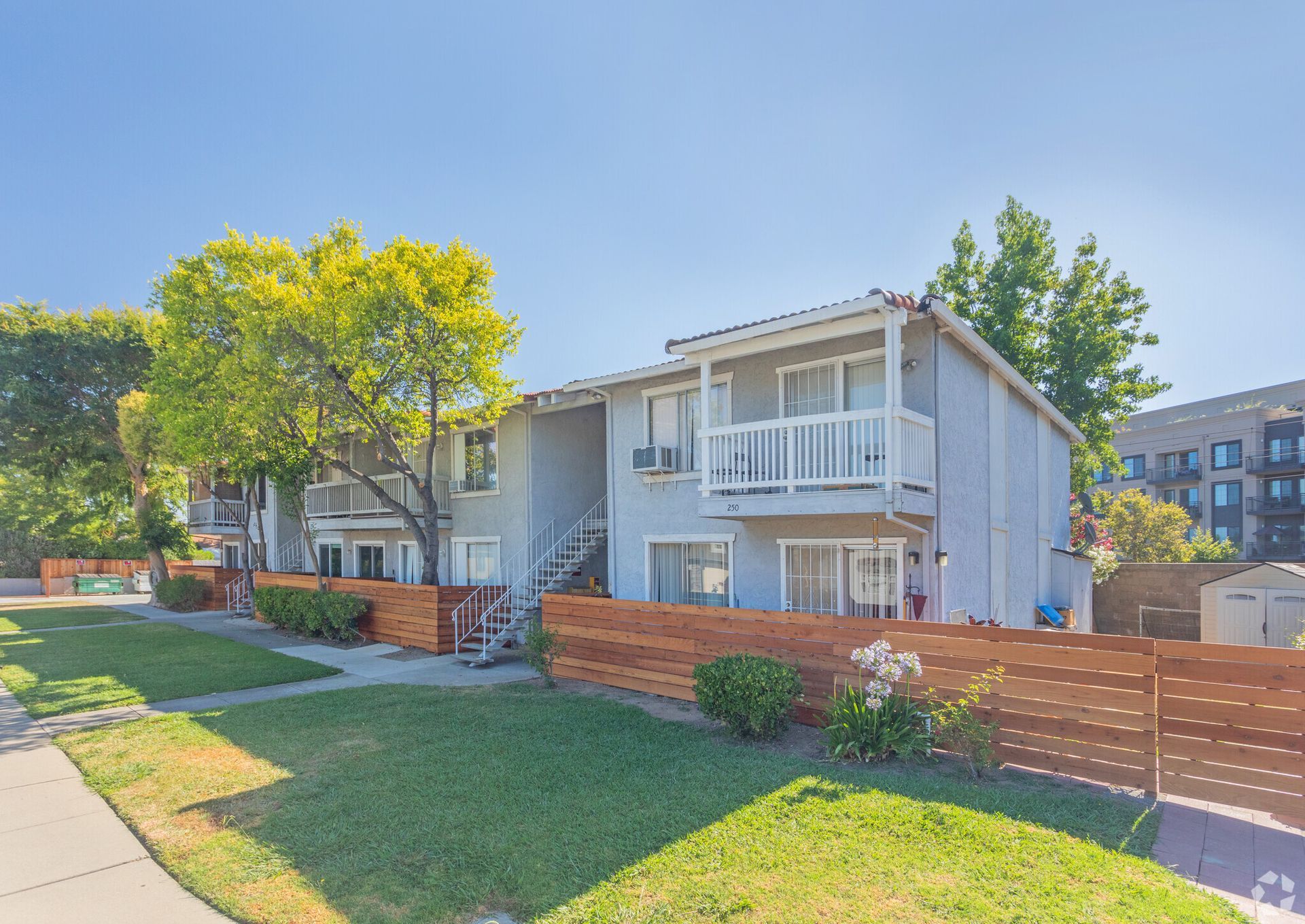 A large apartment building with a wooden fence in front of it