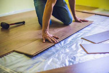 San Jose Flooring Pros are expertly installing new laminate flooring with precision and care. The skilled installer is seen meticulously positioning wooden planks onto the underlayment, ensuring a seamless surface. A rubber mallet is close by to assist with fitting the pieces snugly together. This attention to detail and expertise showcases the high-quality work of flooring installers in San Jose. For top-notch laminate flooring installation in San Jose, trust San Jose Flooring Pros for a flawless finish.