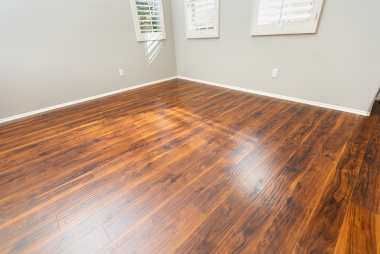 San Jose Flooring Pros presents this stunning image of a rich, warm-toned hardwood floor with a glossy finish that beautifully reflects the natural light coming in through the window. The deep color of the wood adds a touch of luxury and coziness to the room, elevating its overall aesthetic appeal. Whether for your home or office, this hardwood floor is perfect for anyone looking to infuse elegance and timeless beauty into their space. Trust San Jose Flooring Pros to bring this level of sophistication and quality to your flooring projects.