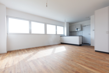 This stunning photo, brought to you by San Jose Flooring Pros, showcases a spacious and well-lit room with large windows that fill the space with natural light, beautifully highlighting the warm tones of the high-quality wooden flooring. The clean lines and minimalist design of the room perfectly accentuate the elegant and durable hardwood floor, which serves as the focal point of this modern living space. The rich texture and natural grain of the flooring provide a timeless appeal that complements any interior design style. For all your flooring needs in San Jose, including vinyl flooring services, trust the experts at San Jose Flooring Pros for top-notch quality and craftsmanship.the best vinyl flooring in San Jose, CA.