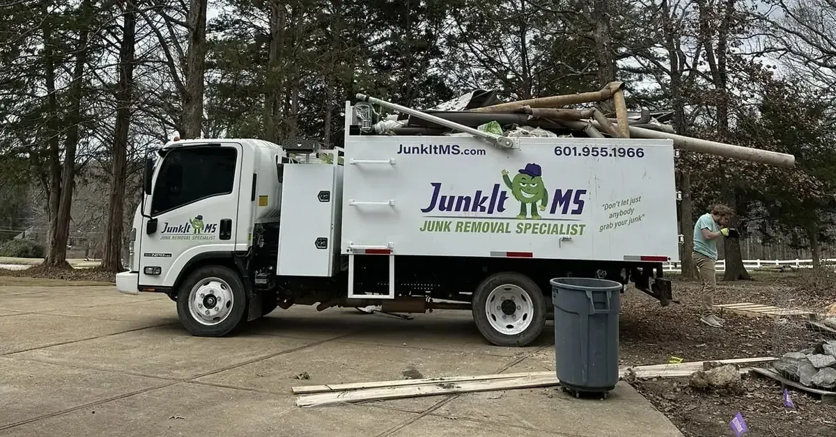 Junk-It MS junk removal truck loaded with debris at a residential property in Jackson, MS