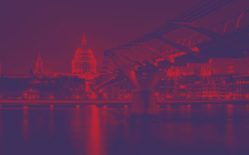A bridge over a body of water with a city in the background.