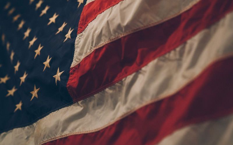 A close up of an american flag waving in the wind.