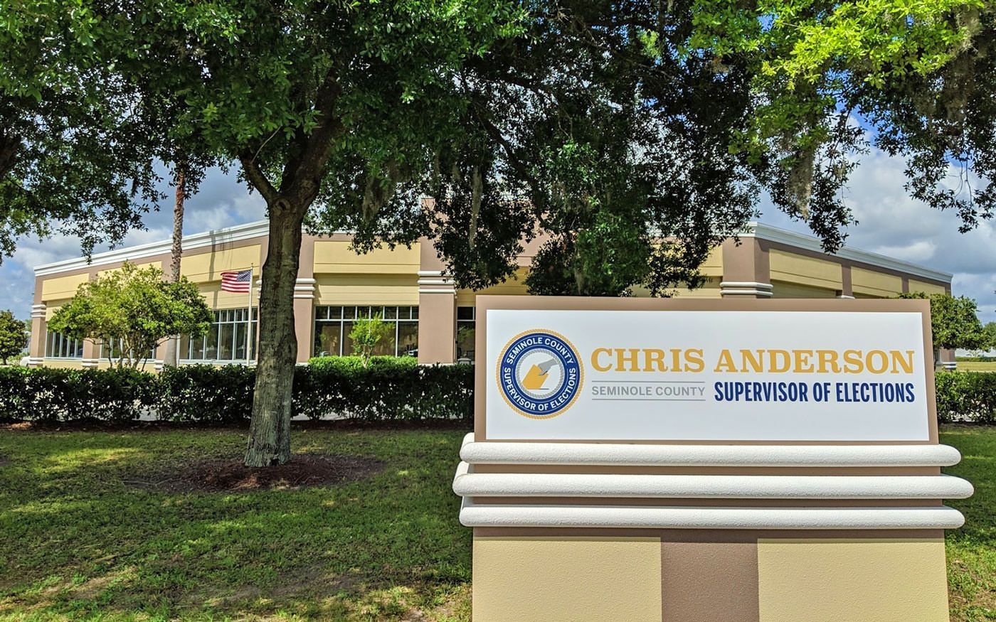 A sign for chris anderson is in front of a building.