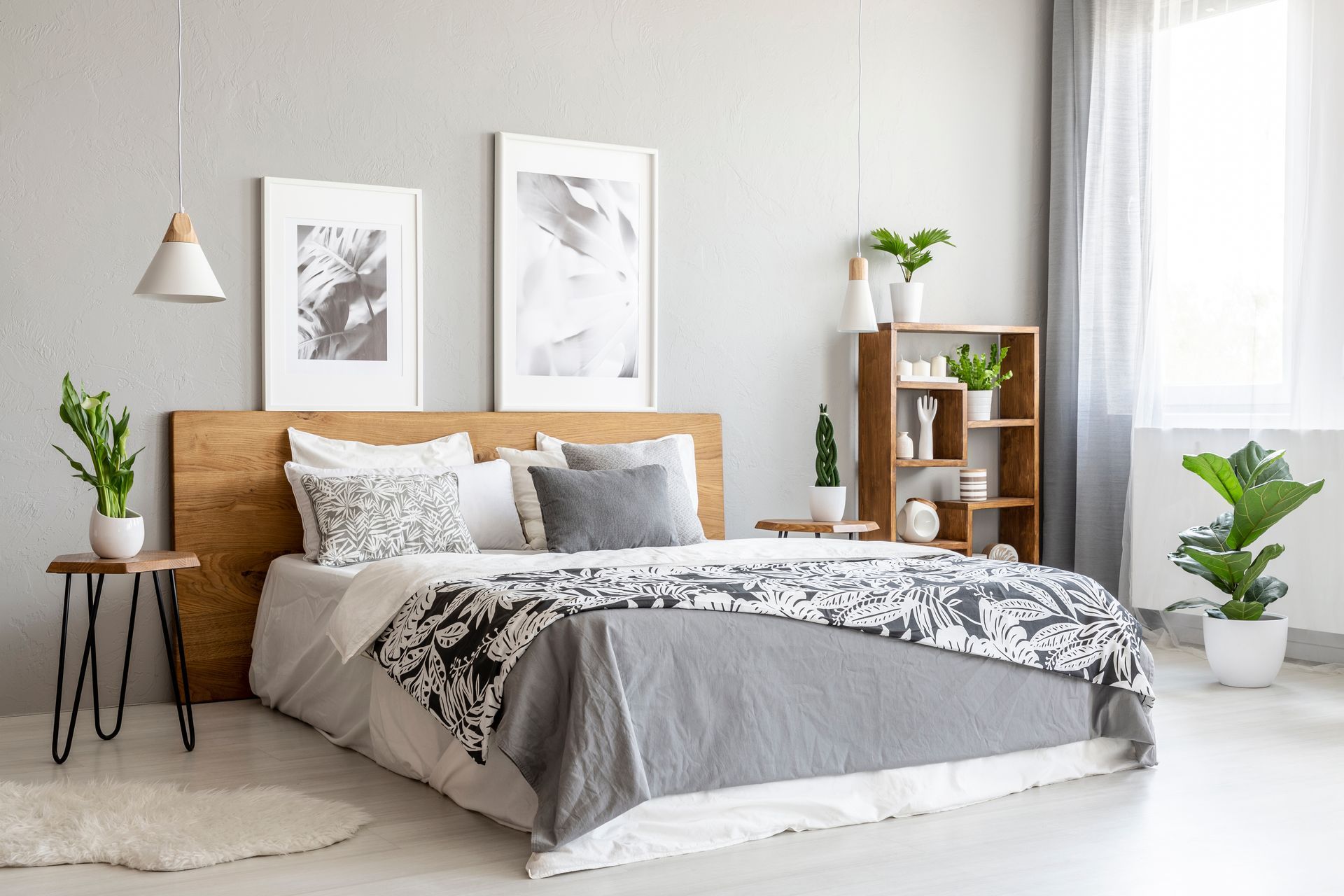 Bedroom with gray walls, wooden headboard, bed, decorative pillows, and plant accents.