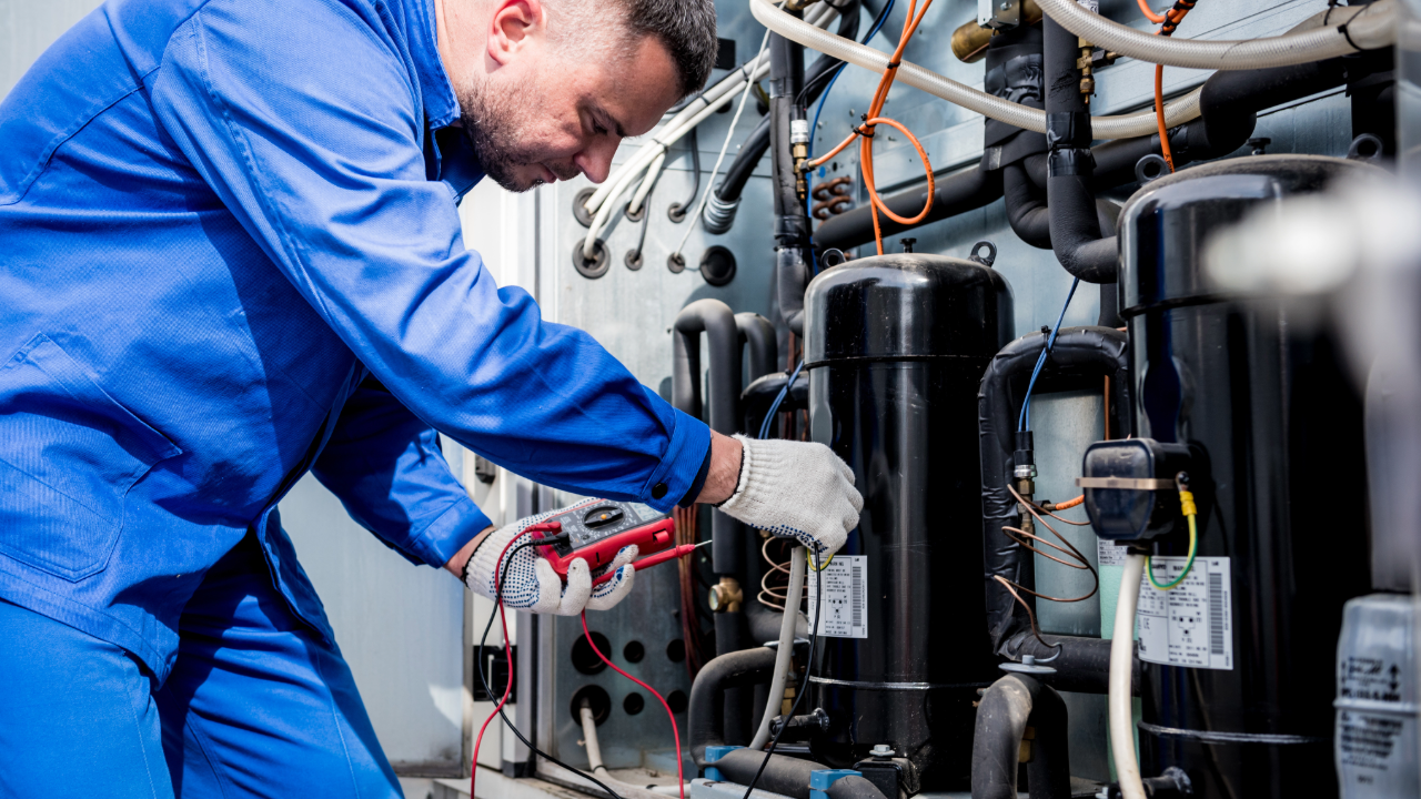 A man in a blue uniform is working on a machine.