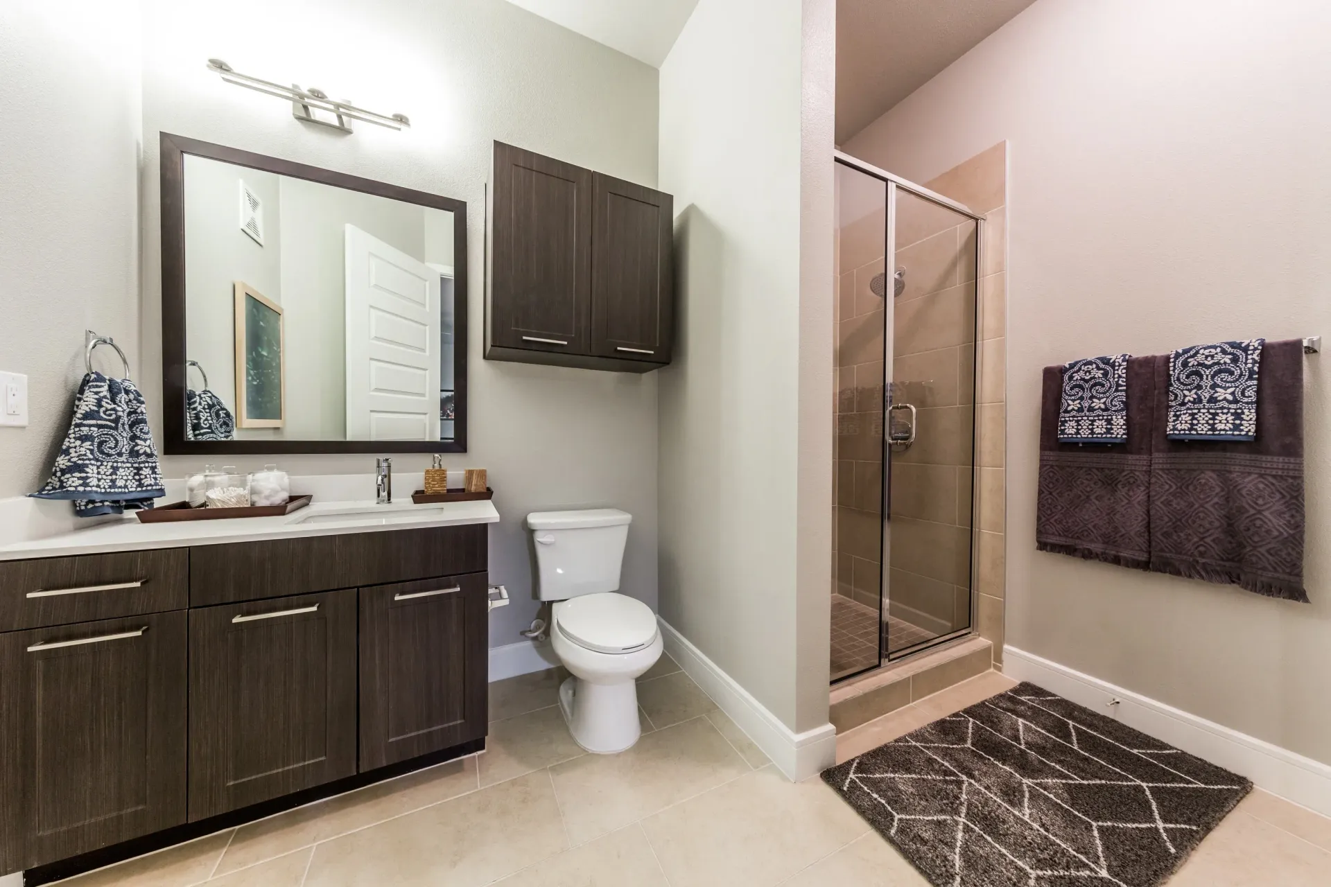 Modern bathroom with vanity, toilet, and glass-enclosed shower.