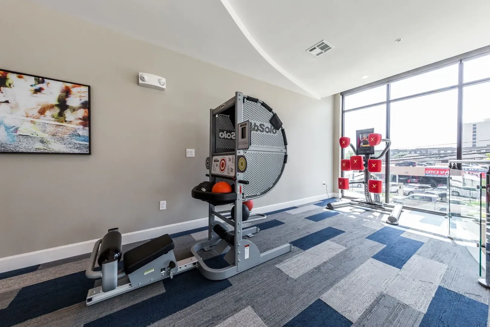 Fitness center with a circular exercise machine and a boxing-style trainer.