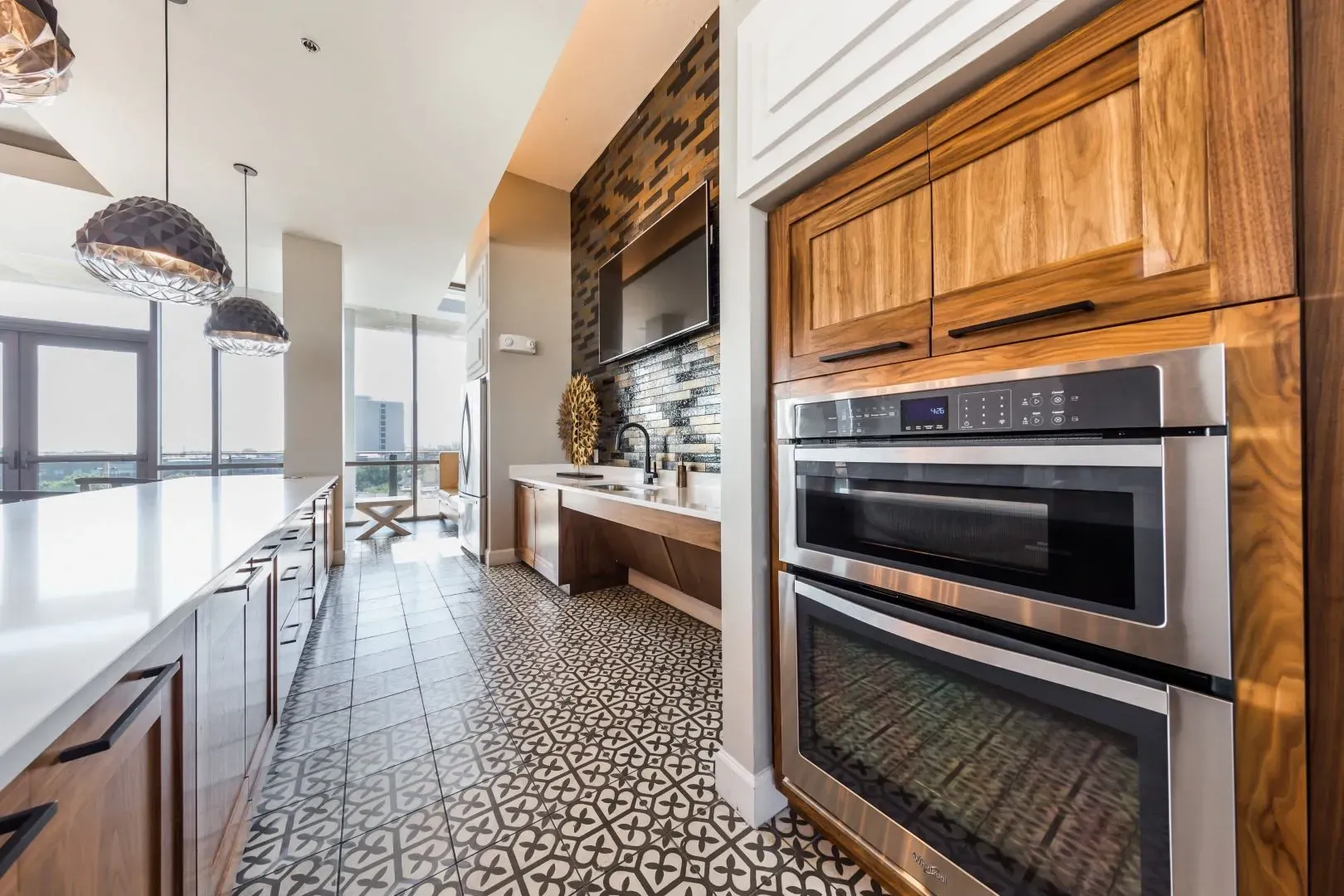 Modern kitchen with double ovens, a sleek island, and city views.