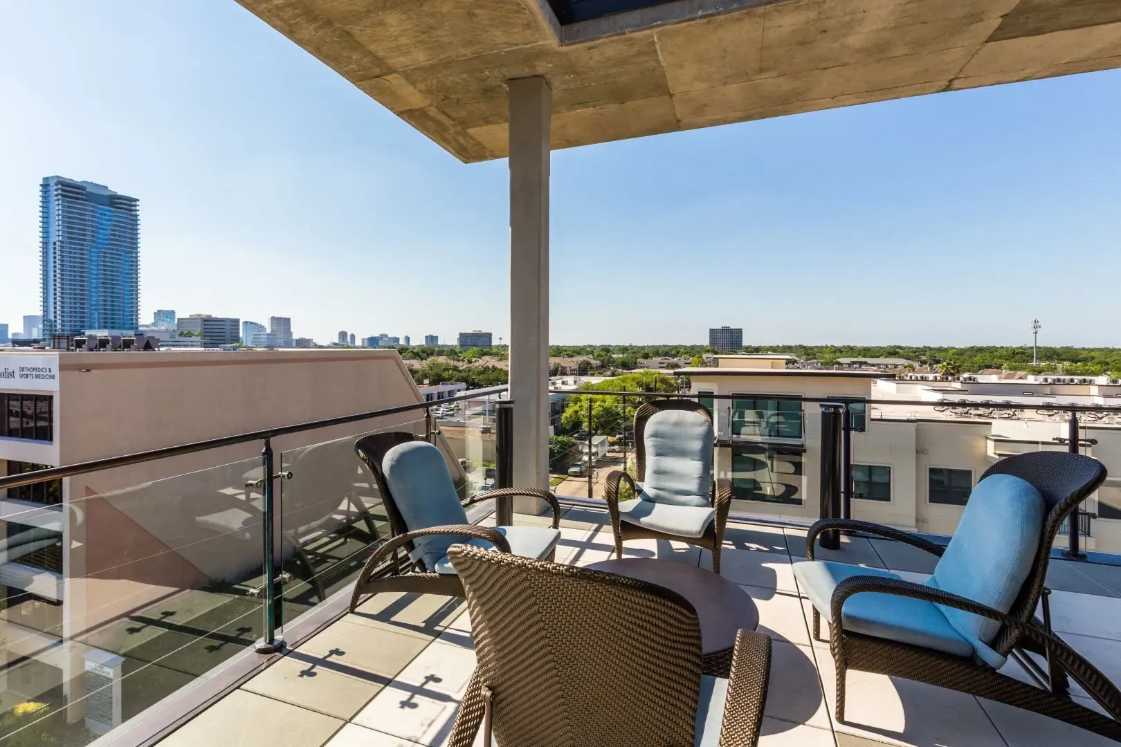 View from balcony with outdoor seating and city skyline