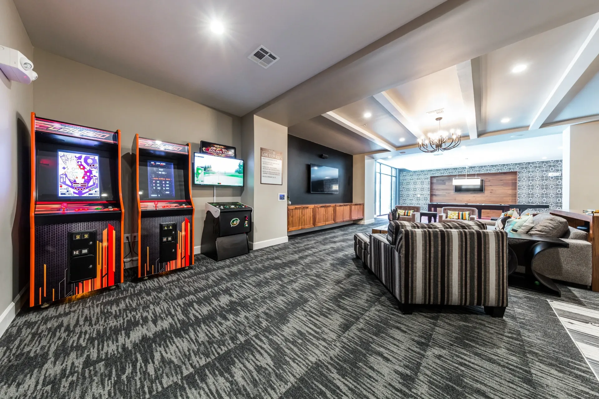 Community lounge with arcade games, seating areas, and pool table.