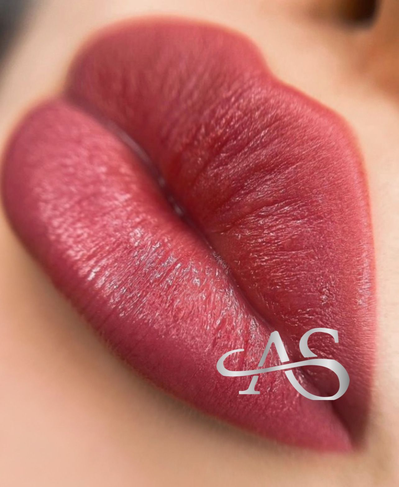 Close-up of plump lips with a deep pink-red lip stain.