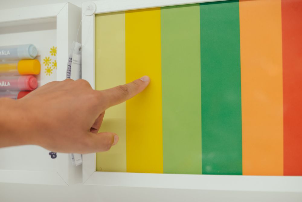 A Hand Points at a Yellow Stripe on a Colourful Gradient — Jamie Frankham Painting in Goonellabah, NSW