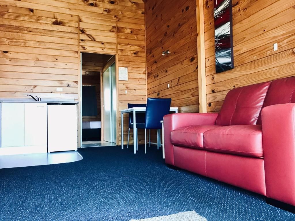 A living room with a red couch and a blue chair