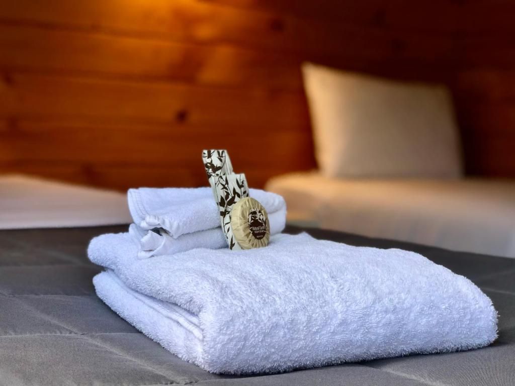 A stack of white towels sitting on top of a bed.