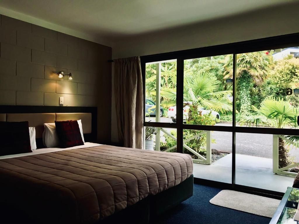 A hotel room with a large bed and a sliding glass door