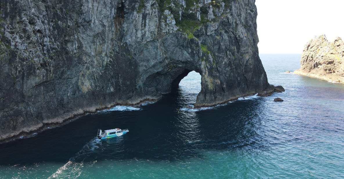 A boat is going through a cave in the middle of the ocean.